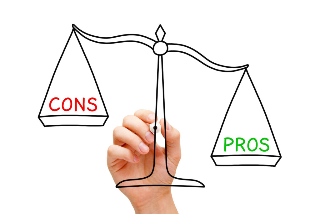 A hand holding a balance scale with 'PROS' in green outweighing 'CONS' in red, illustrating Ricco Coffee Company's view that the advantages of their product surpass the disadvantages.